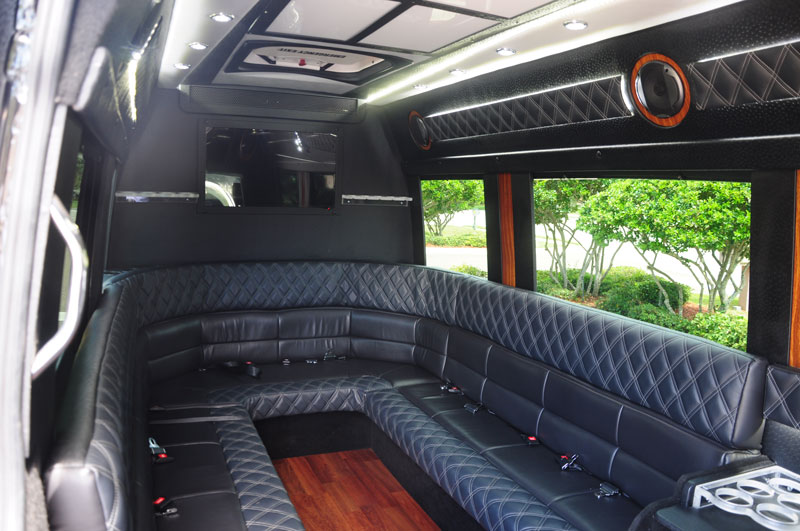 The interior of a black Mercedes van with black seats in the inside.