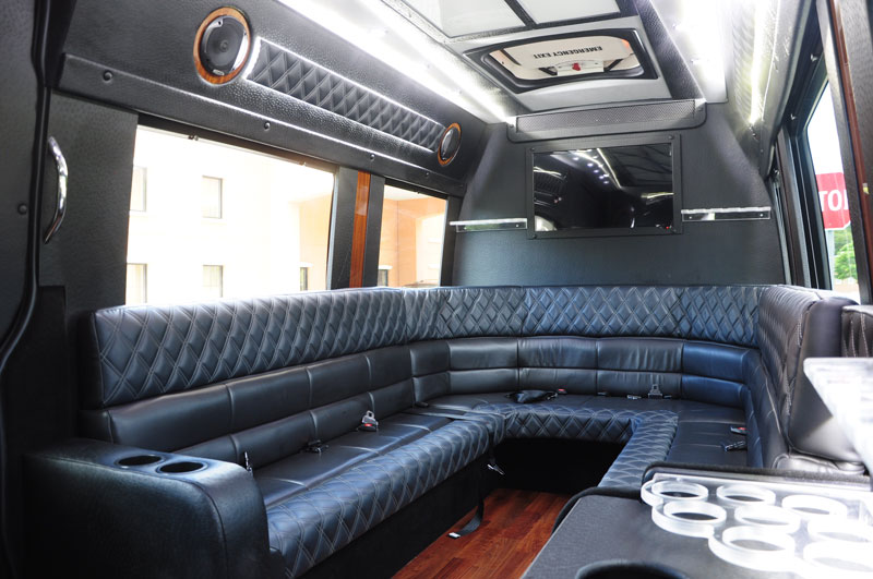 The interior of a black Mercedes van with black seats in the inside.